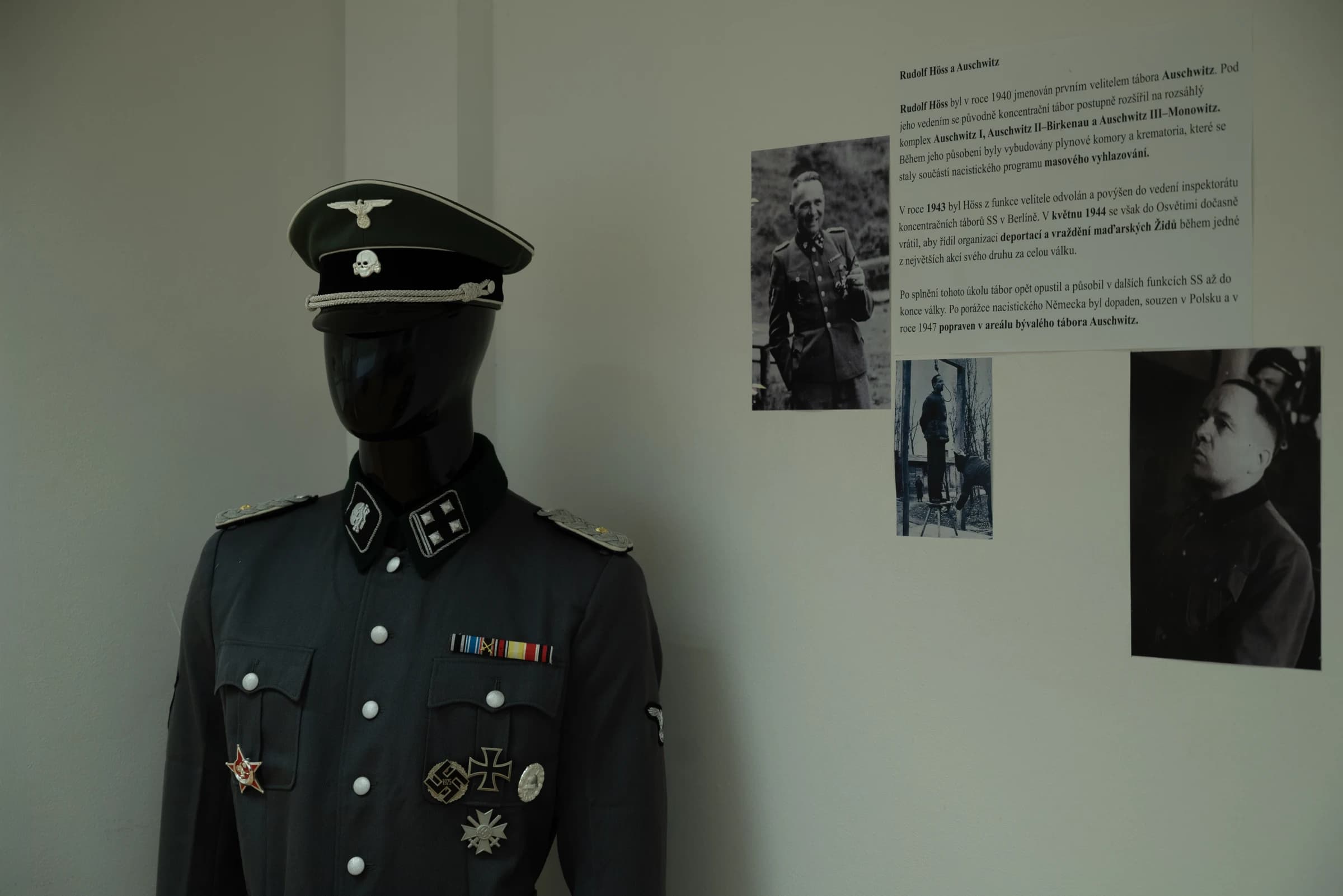 Figurína v historické uniformě SS vedle dokumentačních panelů